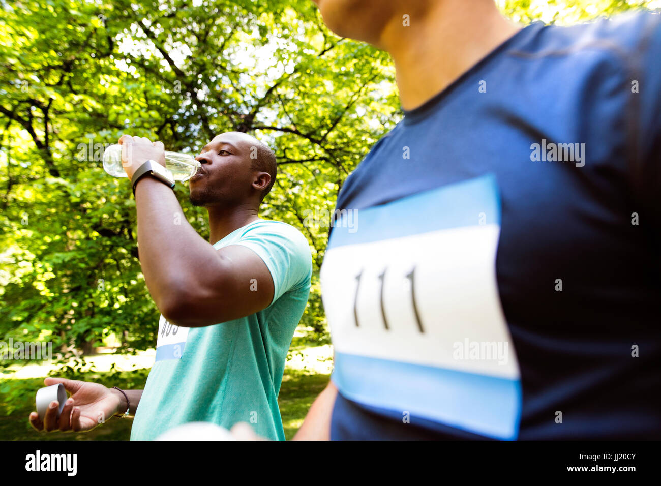Two young athletes prepared for run, drinking water Stock Photo Alamy