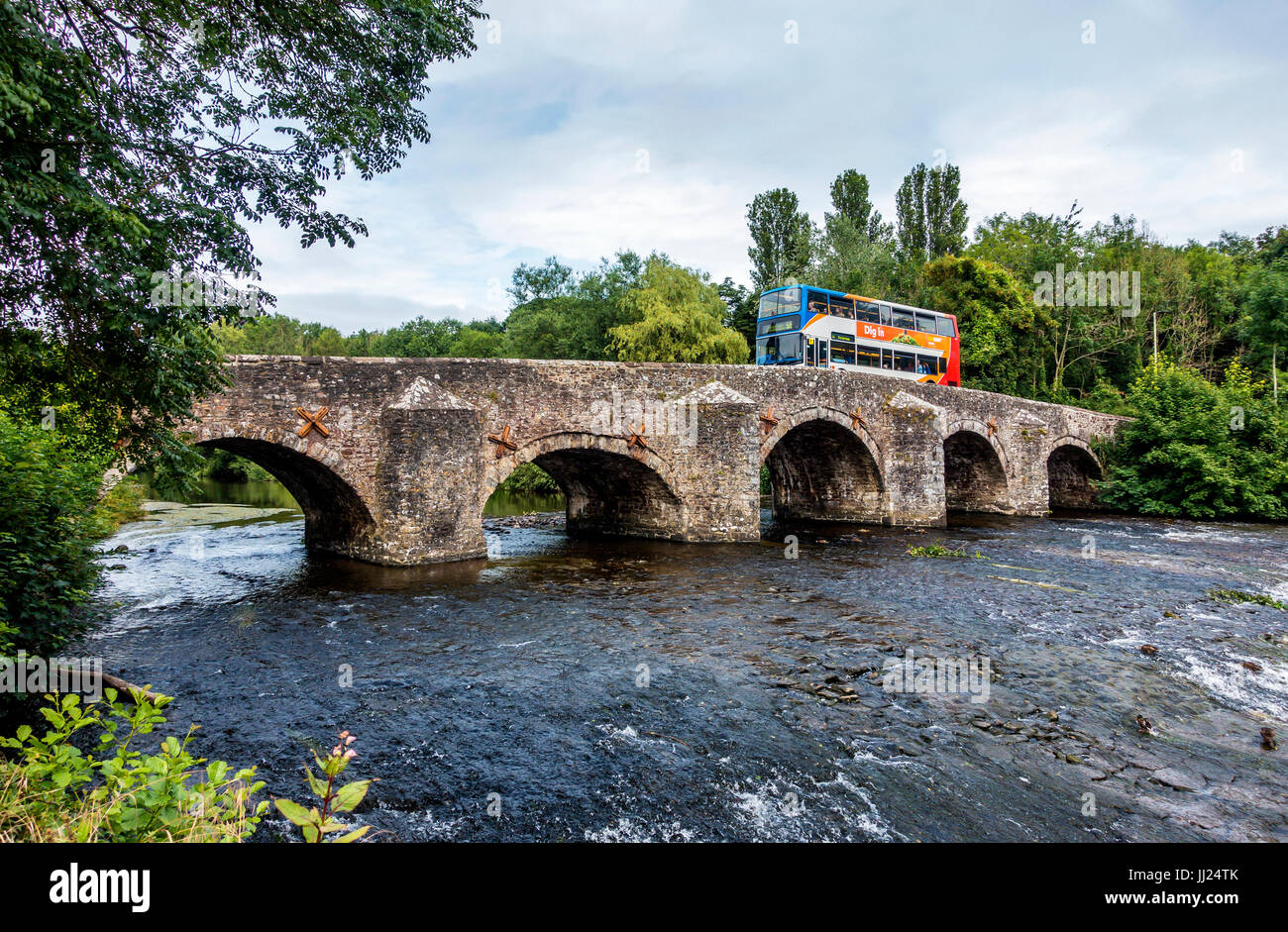 Medieval Bridge with Double Decker Crossing Bickleigh Devon. A five arch stone bridge crossing the river Exe below Tiverton, built in 1809 and listed  Stock Photo