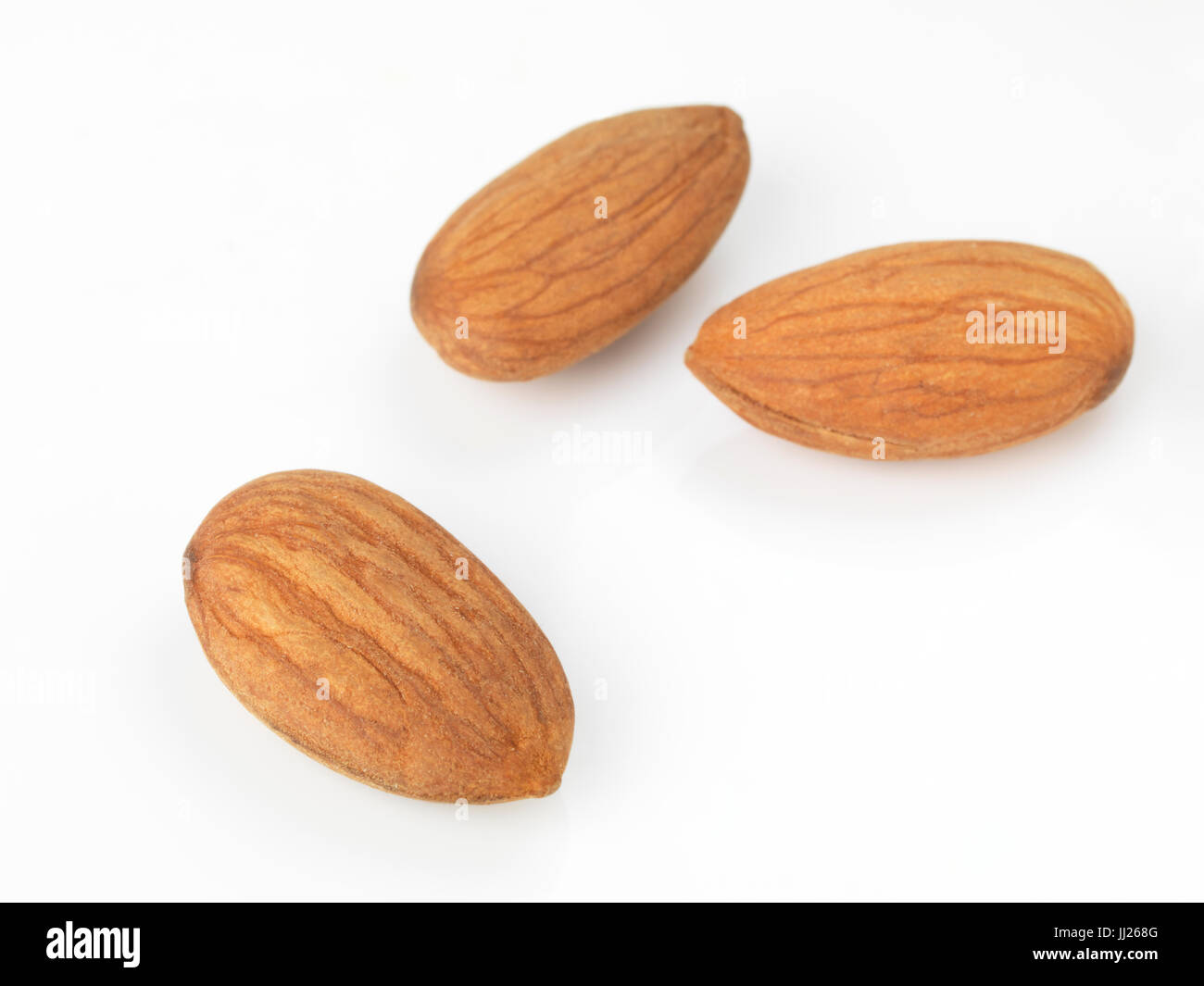 Closeup of three almonds, almond seeds isolated on white background Stock Photo