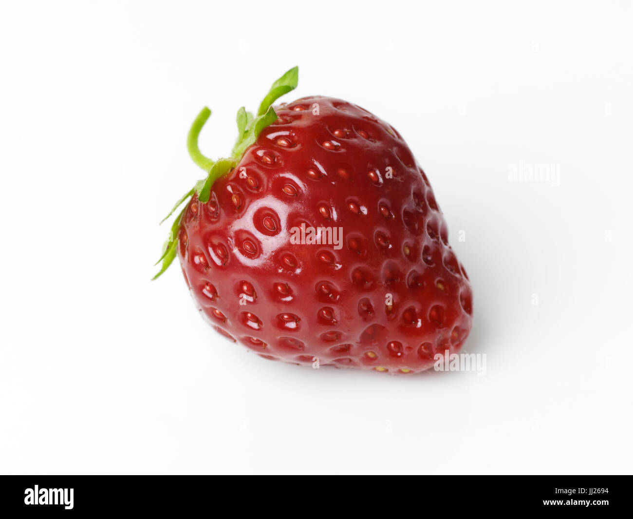 Closeup of a red organic homegrown strawberry isolated on white studio background Stock Photo