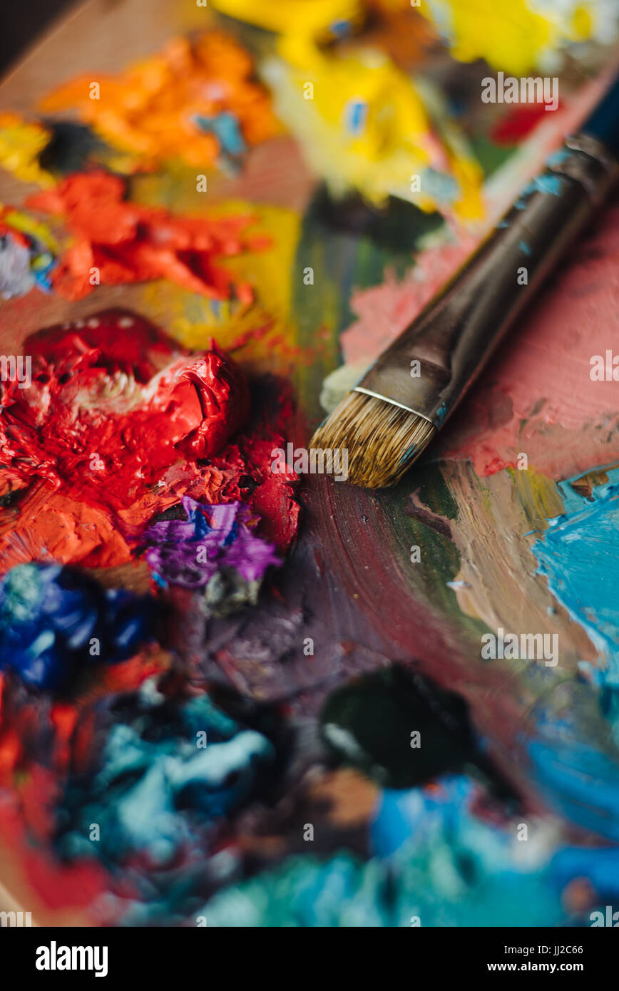 color palette with fresh paint and brush on wood table Stock Photo