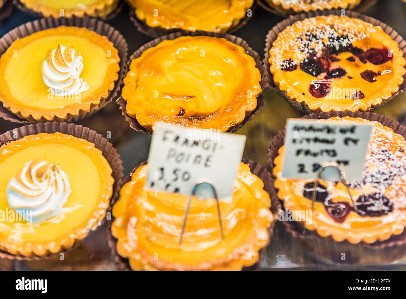 Small lemon meringue tarts with whipped egg whites on display in bakery