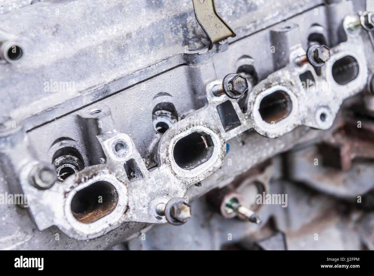Exhaust gas exit ports on an old engine block with the exhaust manifold removed. Stock Photo