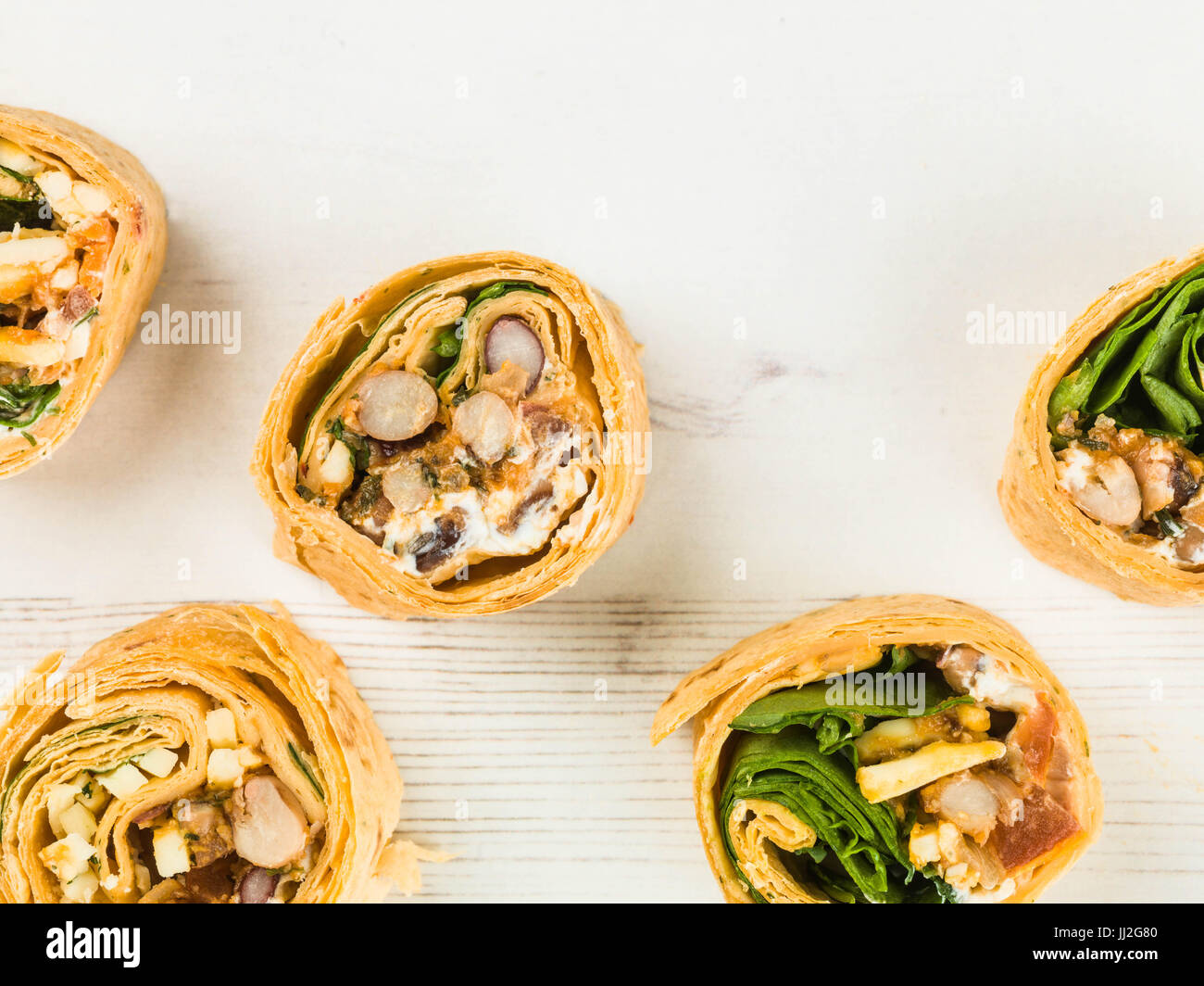 Mexican Style Three Bean Vegetarian Wrap Against a Distressed Wooden