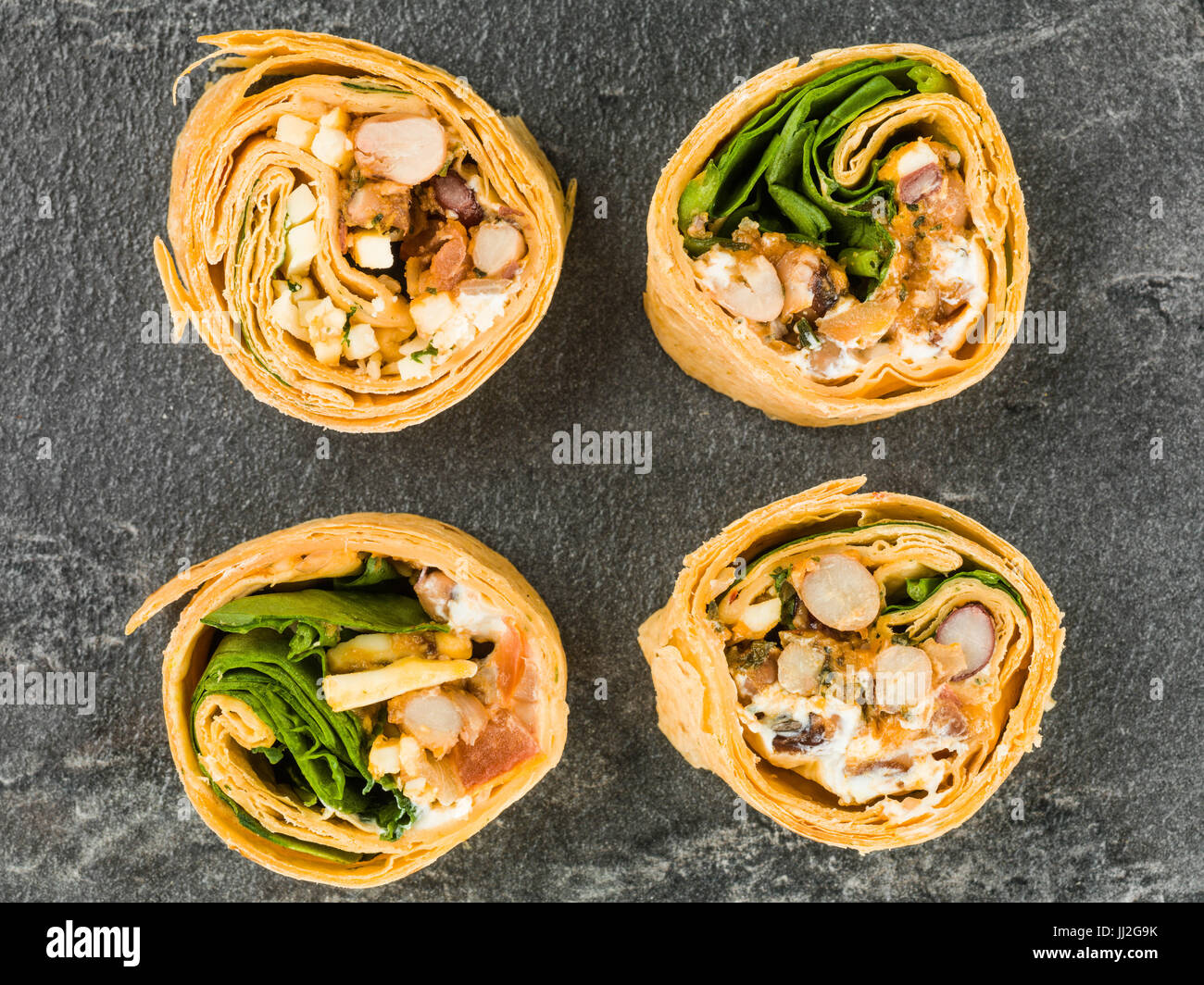 Mexican Style Three Bean Vegetarian Wrap Against a Black Slate Tile