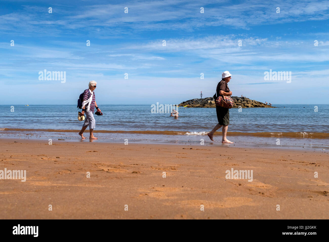 Walking across the sandy beach at Sidmouth,Devon. Stock Photo