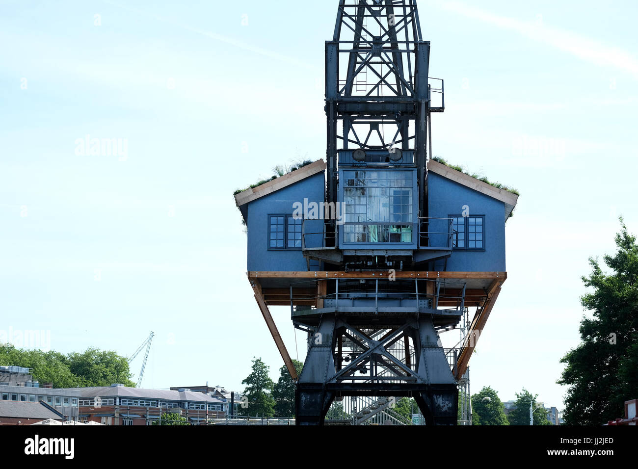 A wooden house constructed half way up and old Bristol Dock crane in Bristol docks, UK Stock Photo