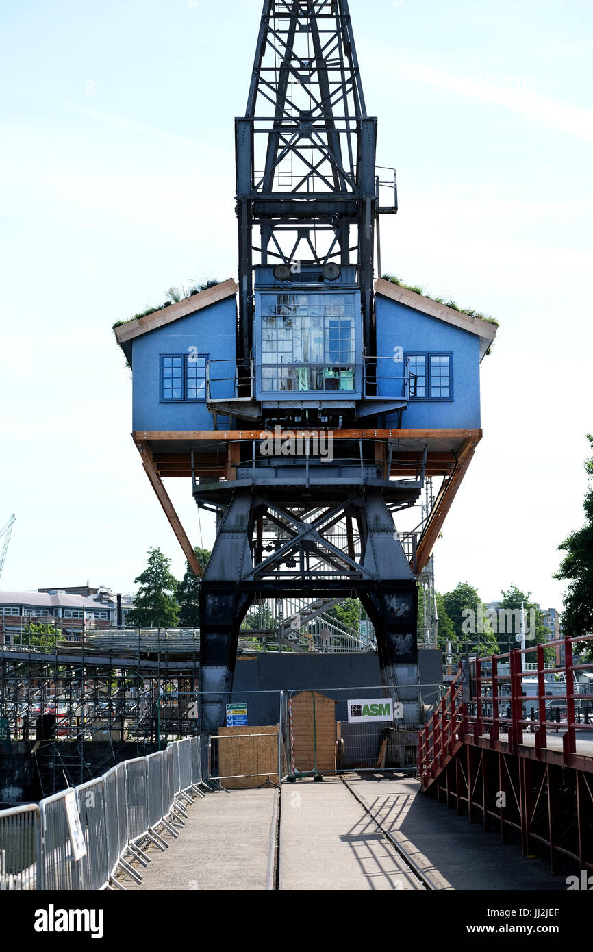 A wooden house constructed half way up and old Bristol Dock crane in Bristol docks, UK Stock Photo