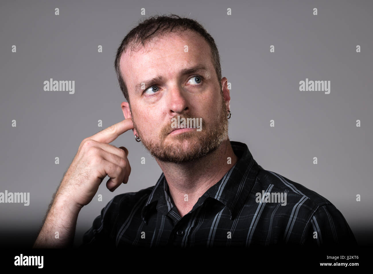 Man Scratches his Ear Stock Photo