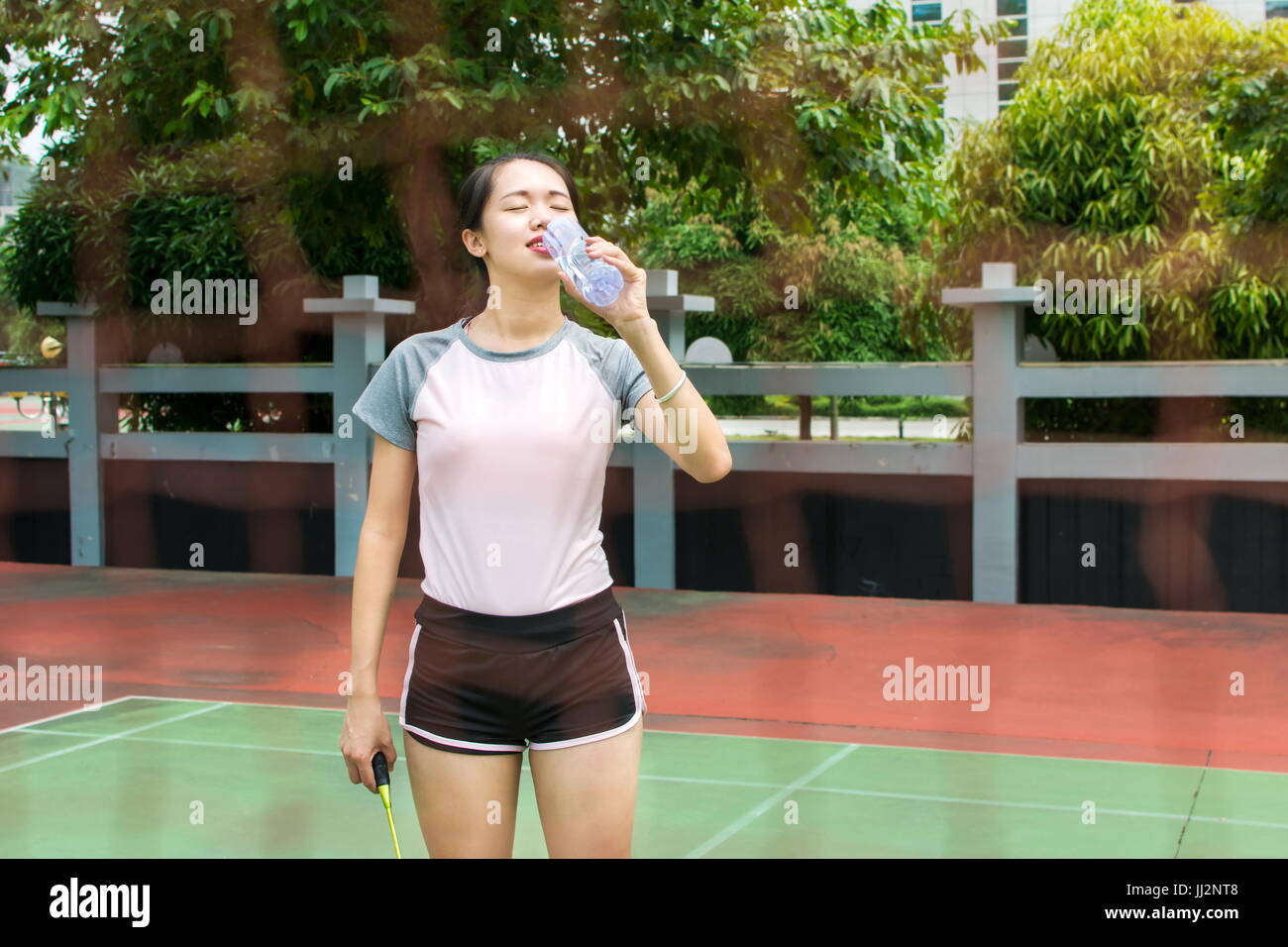 Badminton player wiping sweat on the outdoors court Stock Photo