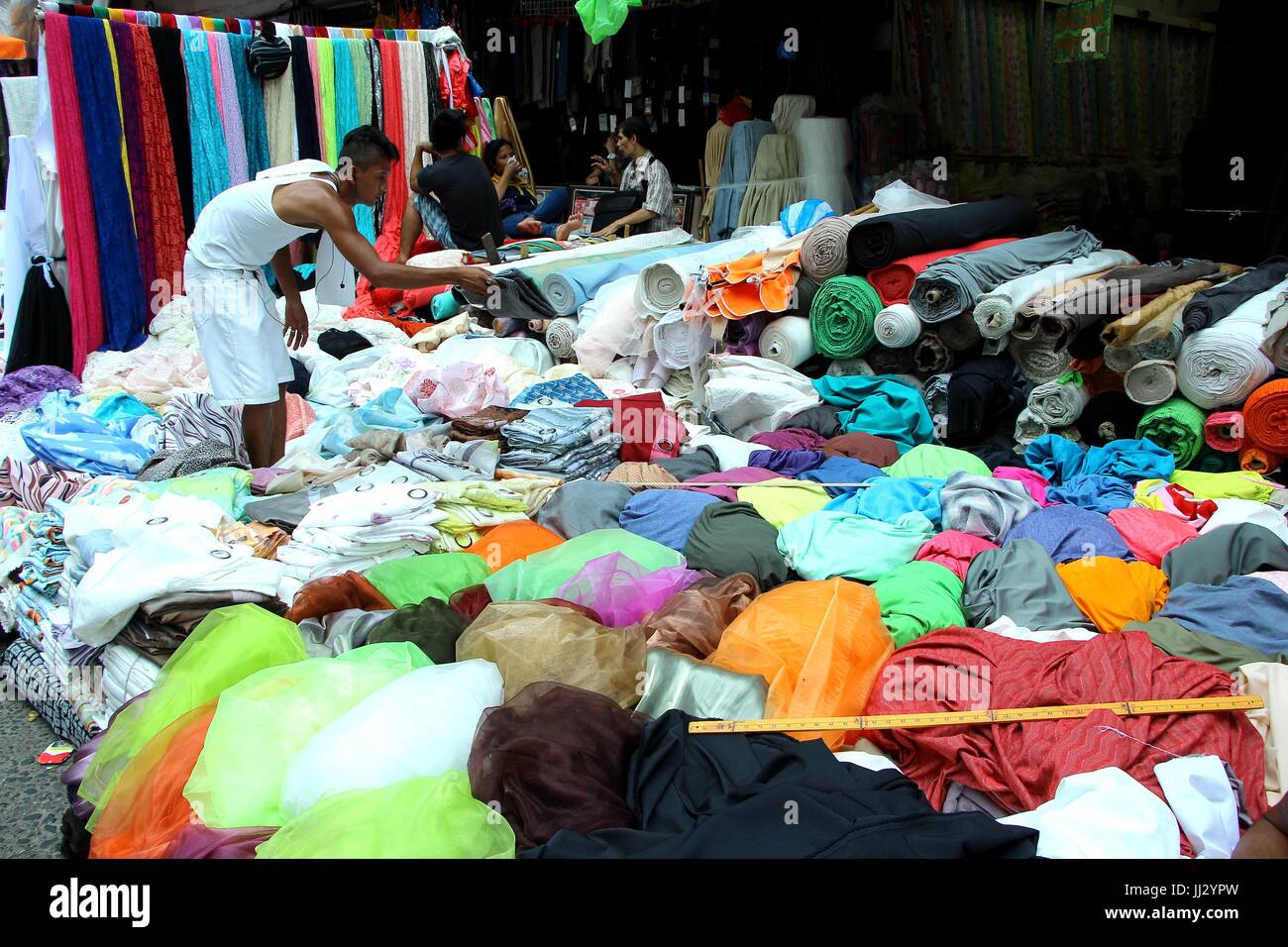 Philippines. 17th July, 2017. A sales person arranges the file of textile at Divisoria Market in Ylaya Street. Manila City on July 17, 2017. Divisoria Market is the heaven place for all dress designers where they bought all their materials for making dress at the cheapest price from US$ 0.50 pesos per yard of textiles depends on the kind of textiles. For budget conscious customers they can buy a readymade dress from 500.00 and wedding gowns that stars from US$ 30 per set. Credit: Gregorio B. Dantes Jr./Pacific Press/Alamy Live News Stock Photo