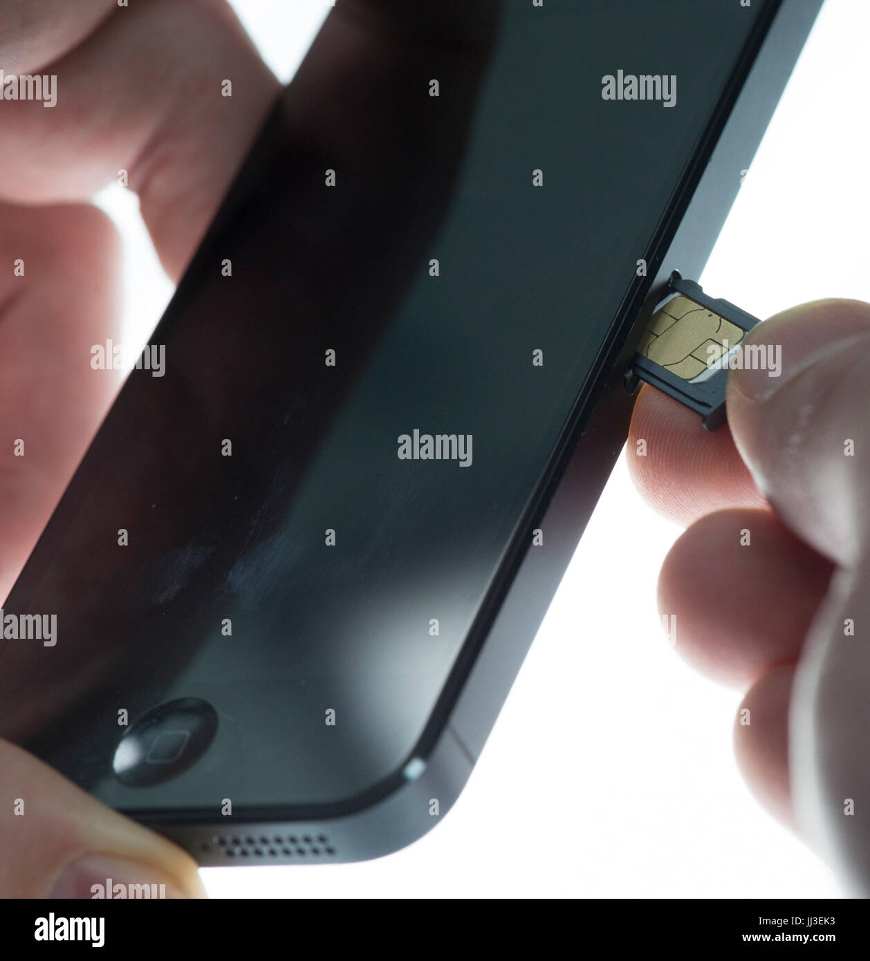 ILLUSTRATION A man installs a SIM card in a mobile telephone in