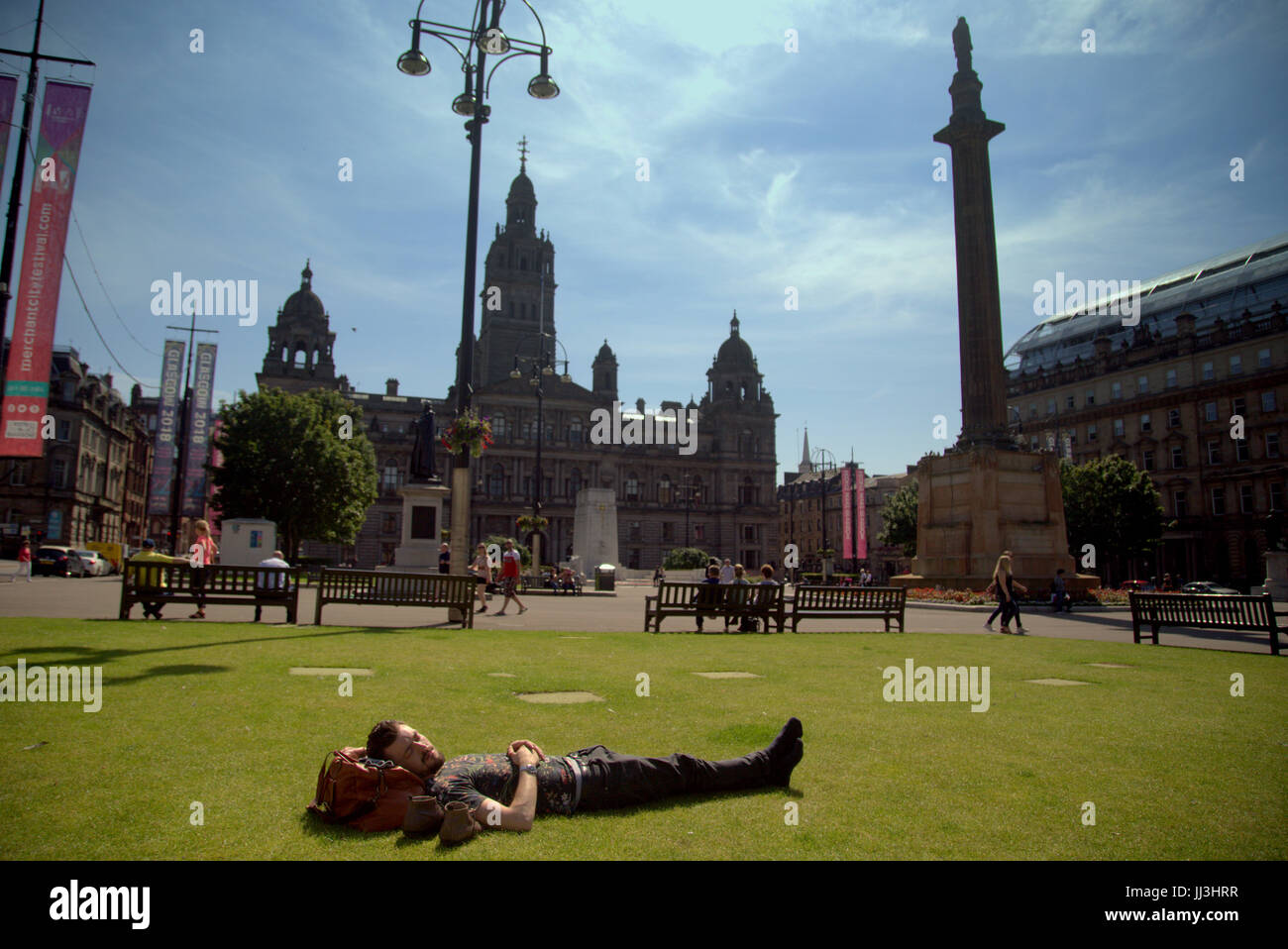 Glasgow, Scotland, UK. 18th July. Summer weather returns and Ed Westwick enjoys the summer in the city's George Square as Scotland catches some of the scorching UK weather Credit Gerard Ferry/Alamy news Stock Photo