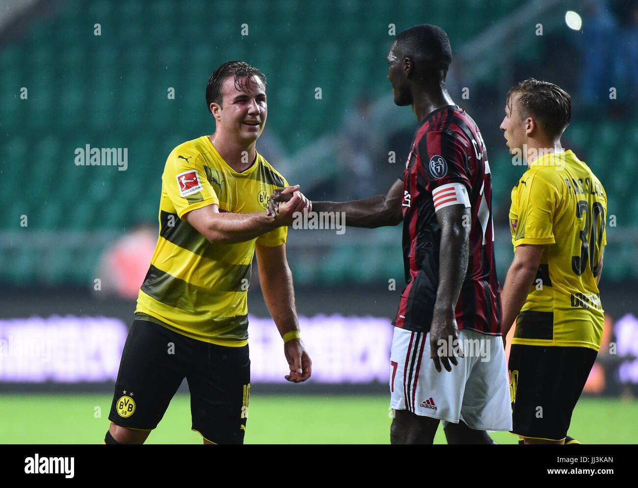 Guangzhou, China. 18th Jul, 2017. Cristian Zapata (C) of AC Milan shakes hands with Mario Gotze (L) of Borussia Dortmund after the 2017 International Champions Cup (ICC) China soccer match at Guangzhou University Town Sports Center Stadium in Guangzhou, capital of south China's Guangdong Province, on July 18, 2017. Borussia Dortmund won 3-1. Credit: Xinhua/Alamy Live News Stock Photo