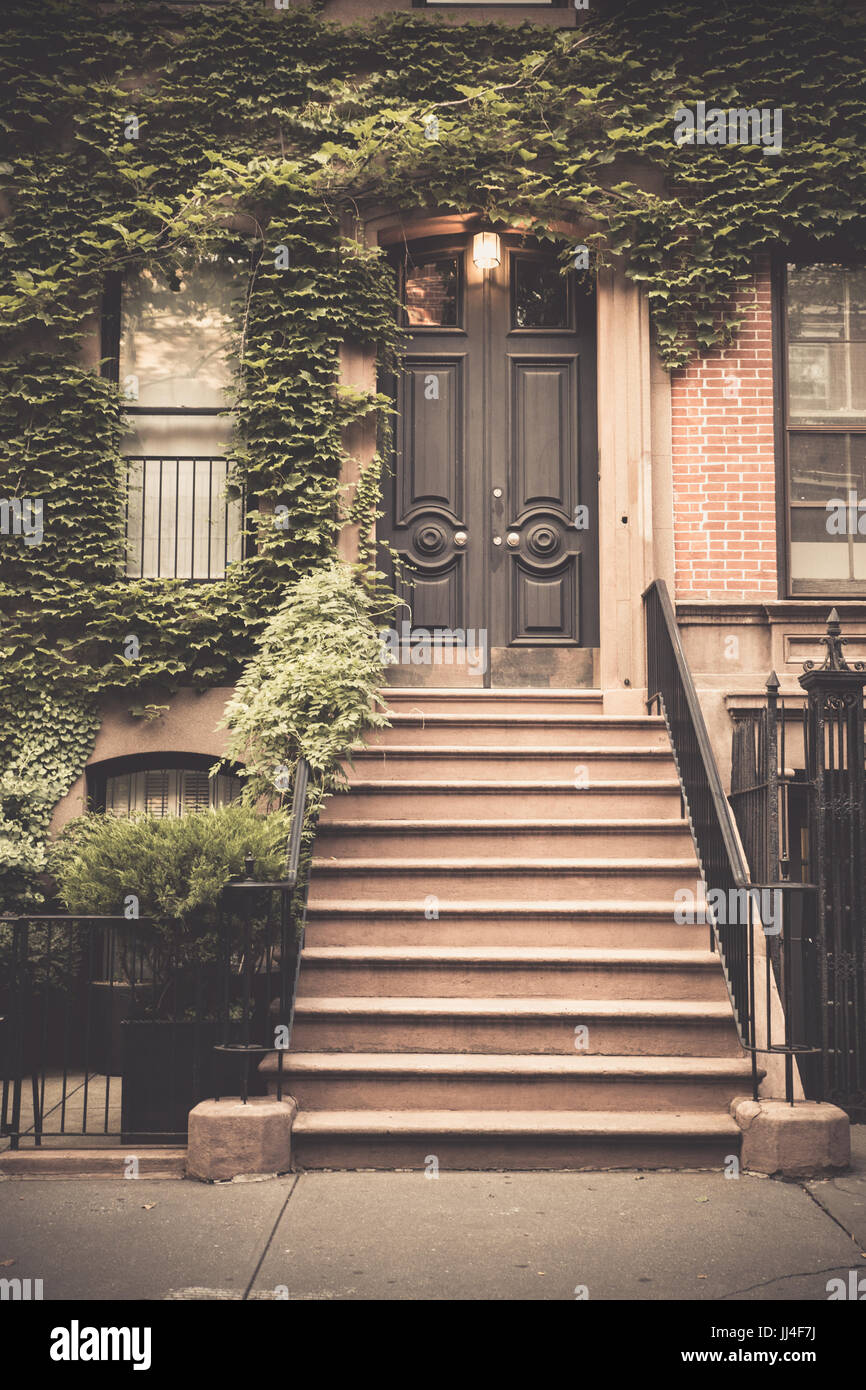 Pretty urban brownstone home with door and front porch in New York City Stock Photo