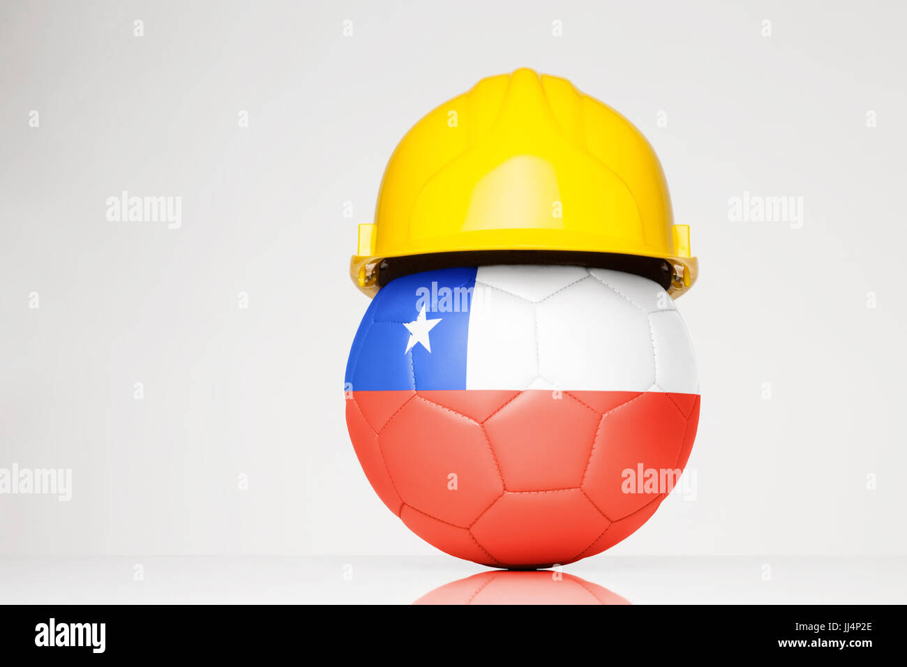 football wearing a hard hat with the Chile flag superimposed on the football Stock Photo