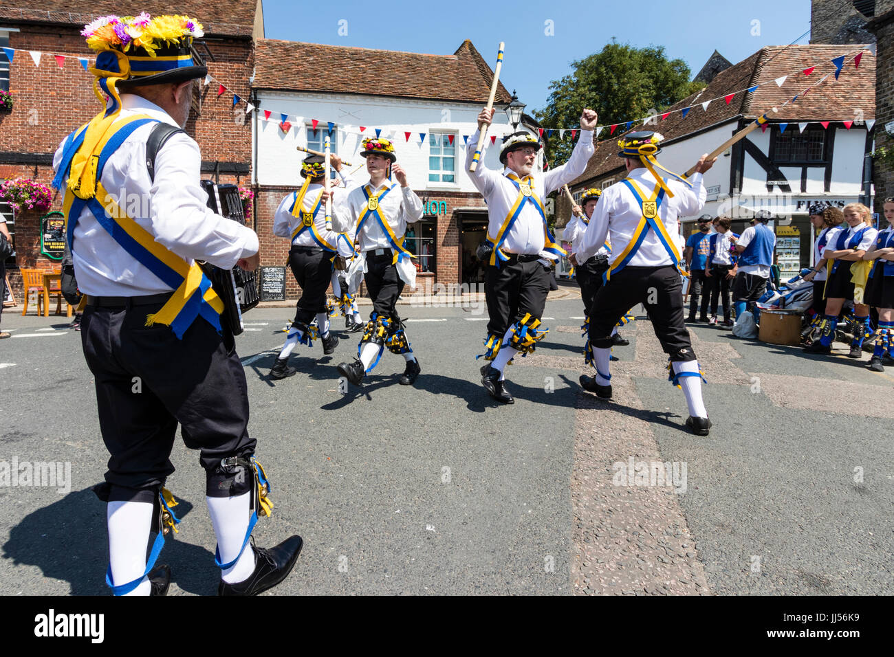 Traditional English folk dancers, Yateley Morris side dancing with accordion in the street in medieval town, Sandwich during folk and ale festival. Stock Photo