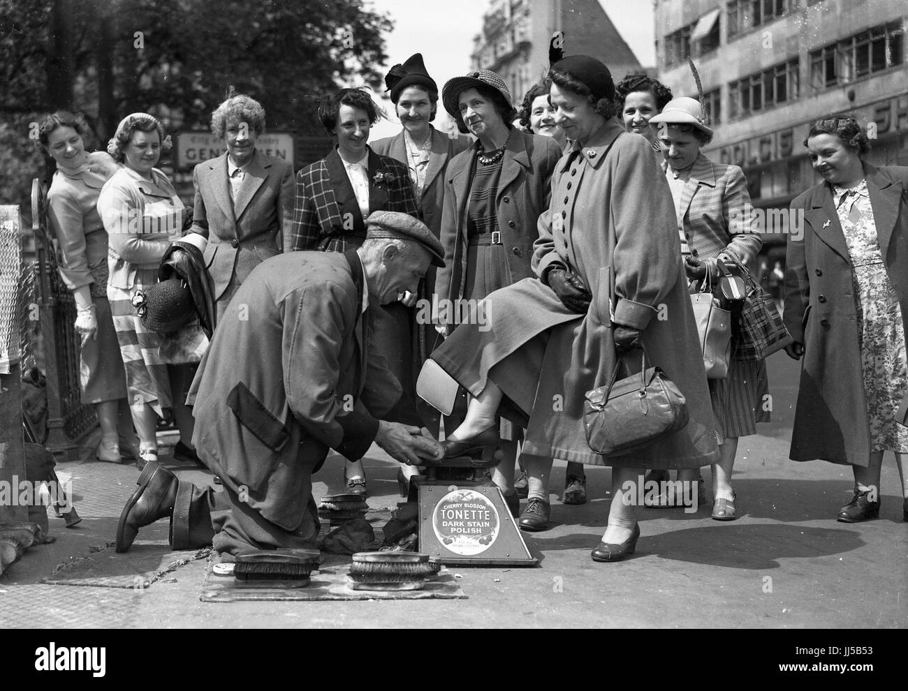 Ladies girls day out in London 1949 with shoe shine man shoeshine Stock Photo