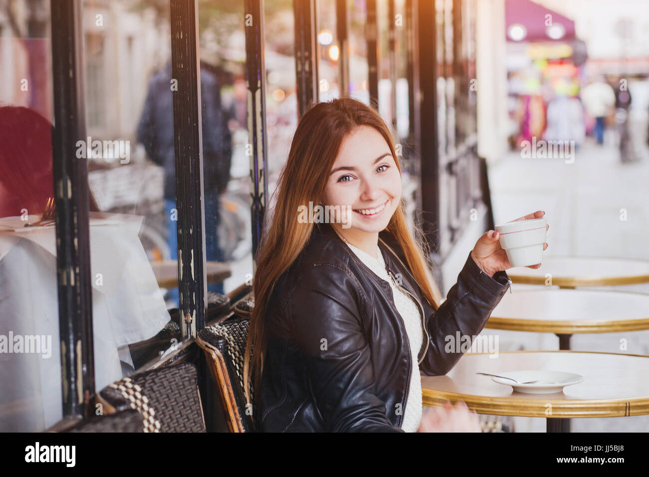 happy smiling woman drinking coffee in street cafe and looking at camera, good mood Stock Photo