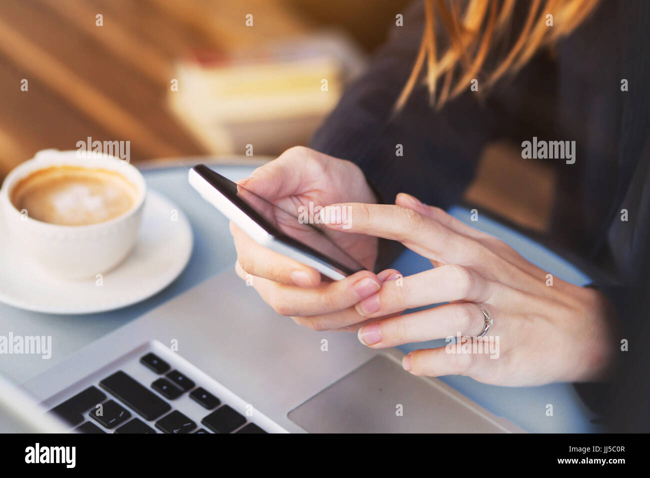 close up of hands using mobile application on smartphone, woman checking emails on her smart phone in cafe Stock Photo