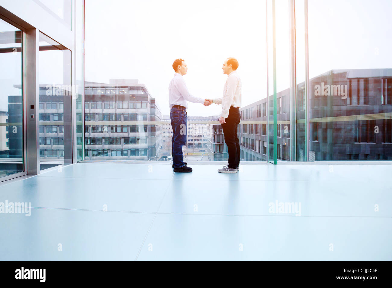 business cooperation concept, collaboration, two business people shaking hands in office interior Stock Photo
