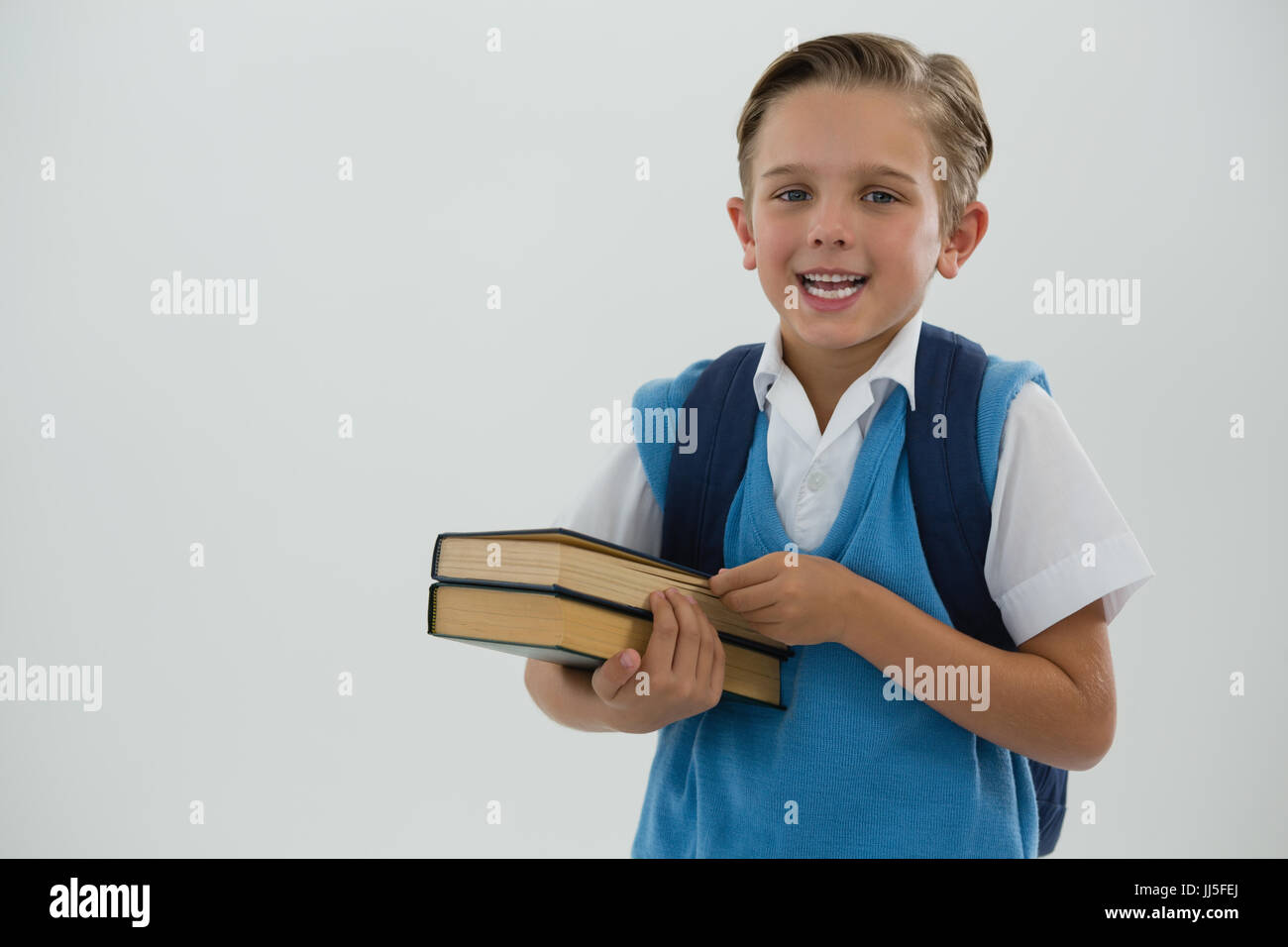 Portrait of happy schoolboy holding books Stock Photo - Alamy