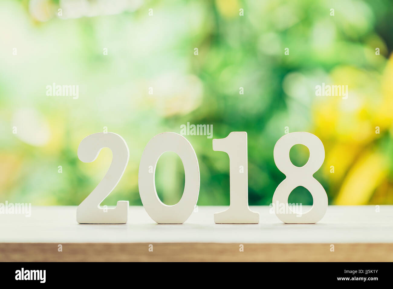 New Year concept for 2018 : Wood numbers 2018 on wood table top and green light bokeh blur background. Stock Photo