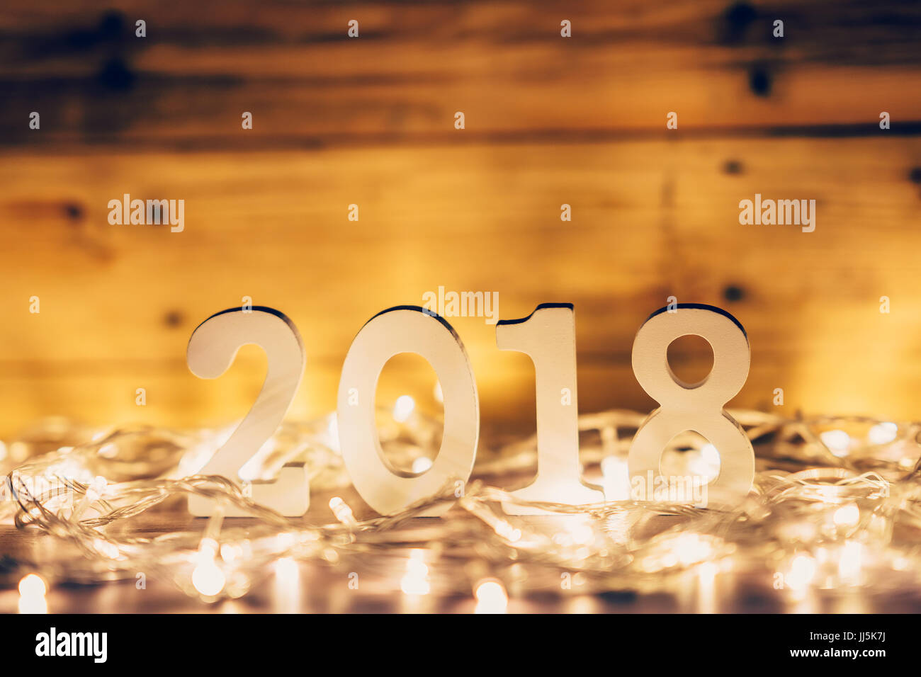 New Year concept for 2018 : Wood numbers 2018 on wood table top and christmas light and blur background. Stock Photo
