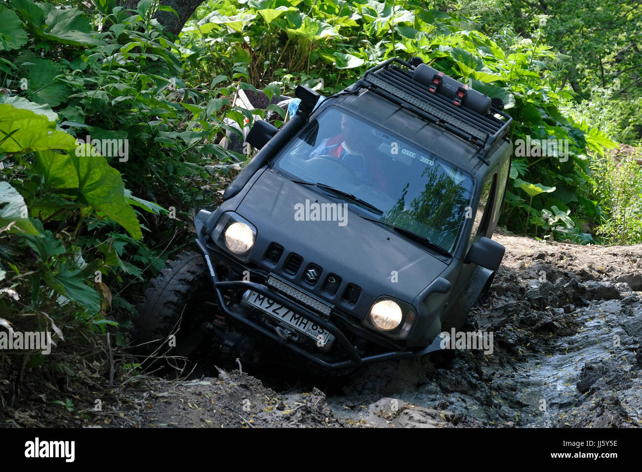 A Suzuki Jimny SUV vehicle crossing a muddy mountainous area in the Korsakovsky District  south eastern side of the island of Sakhalin in the North Pacific Ocean, Russia Stock Photo