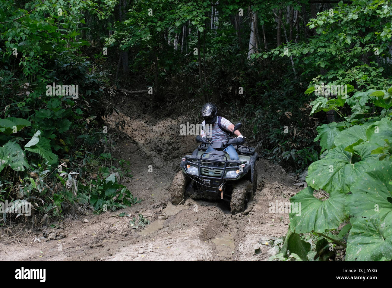 A Russian man rides an allterrain quad bike vehicle ATV in a muddy