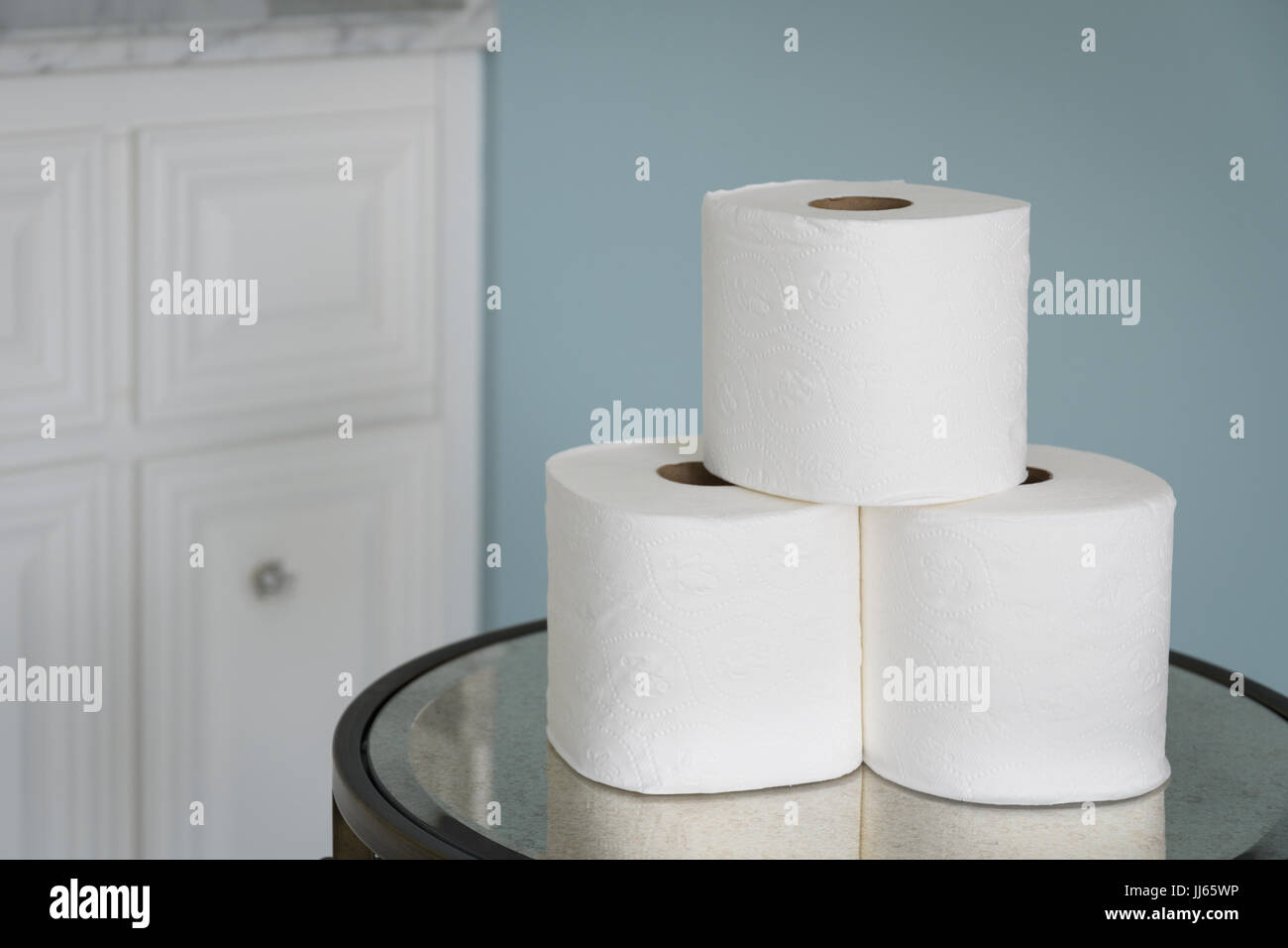 Stack of toilet paper rolls on mirrored table. Stock Photo