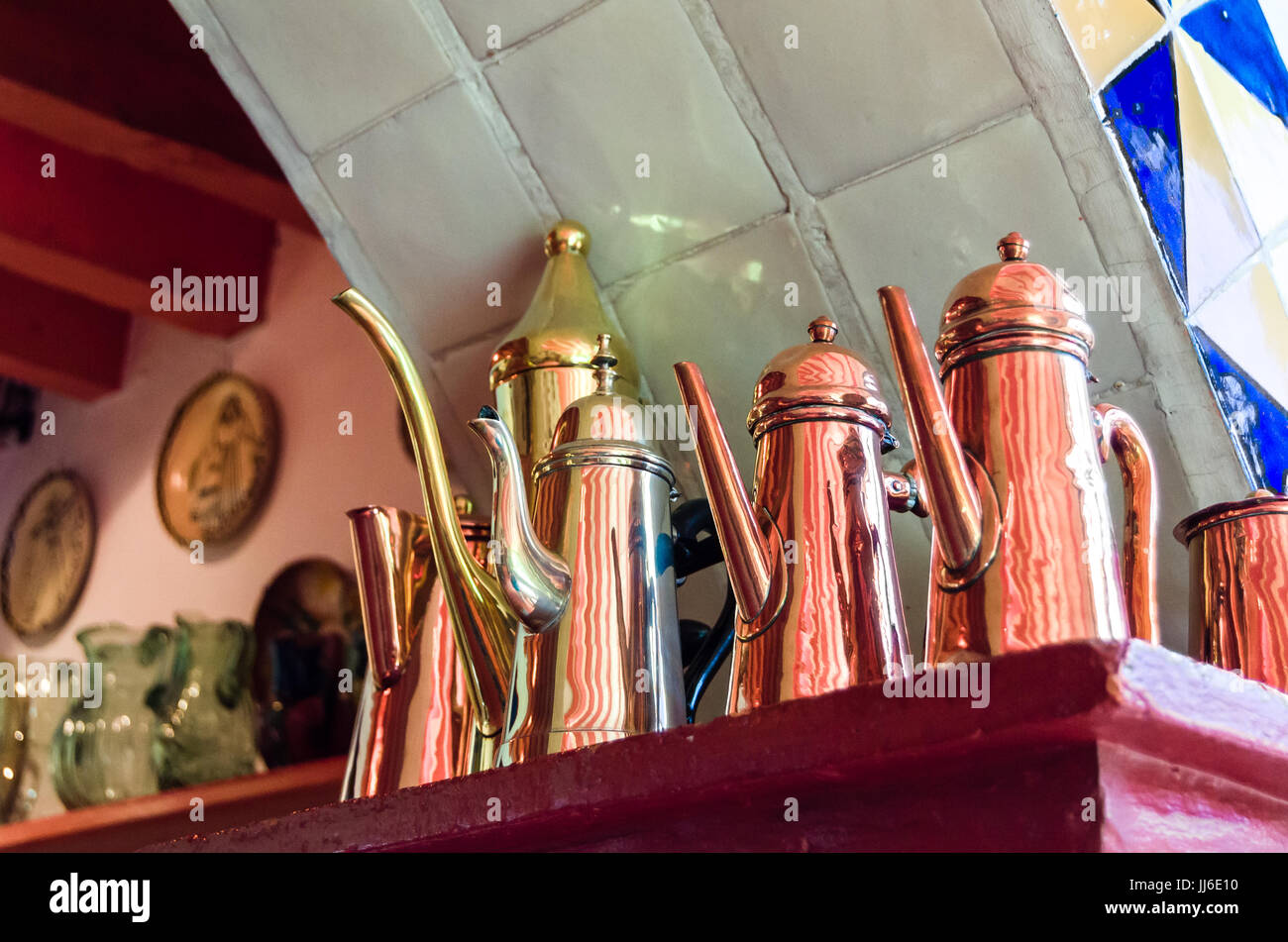 Antique copper jug collection on shelf of an old kitchen Stock Photo