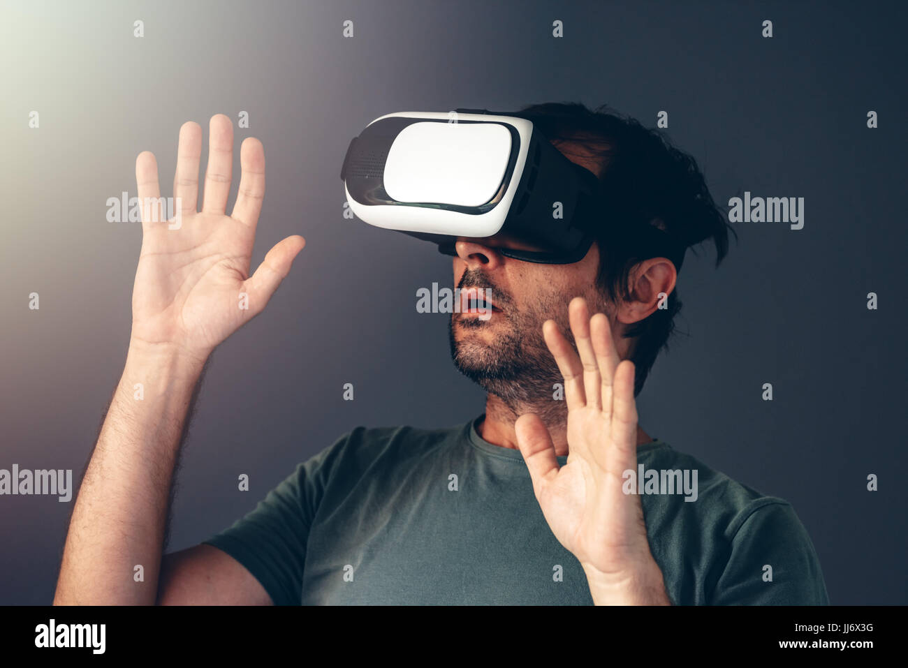 Casual bearded adult man with virtual reality VR headset indoors Stock Photo