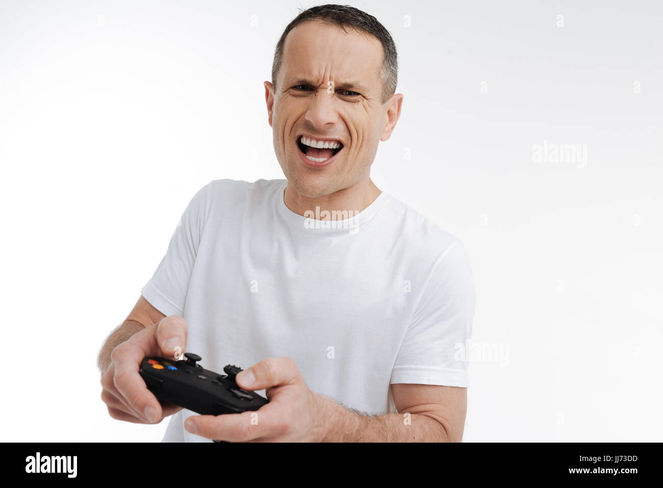 Emotional man playing with game console Stock Photo