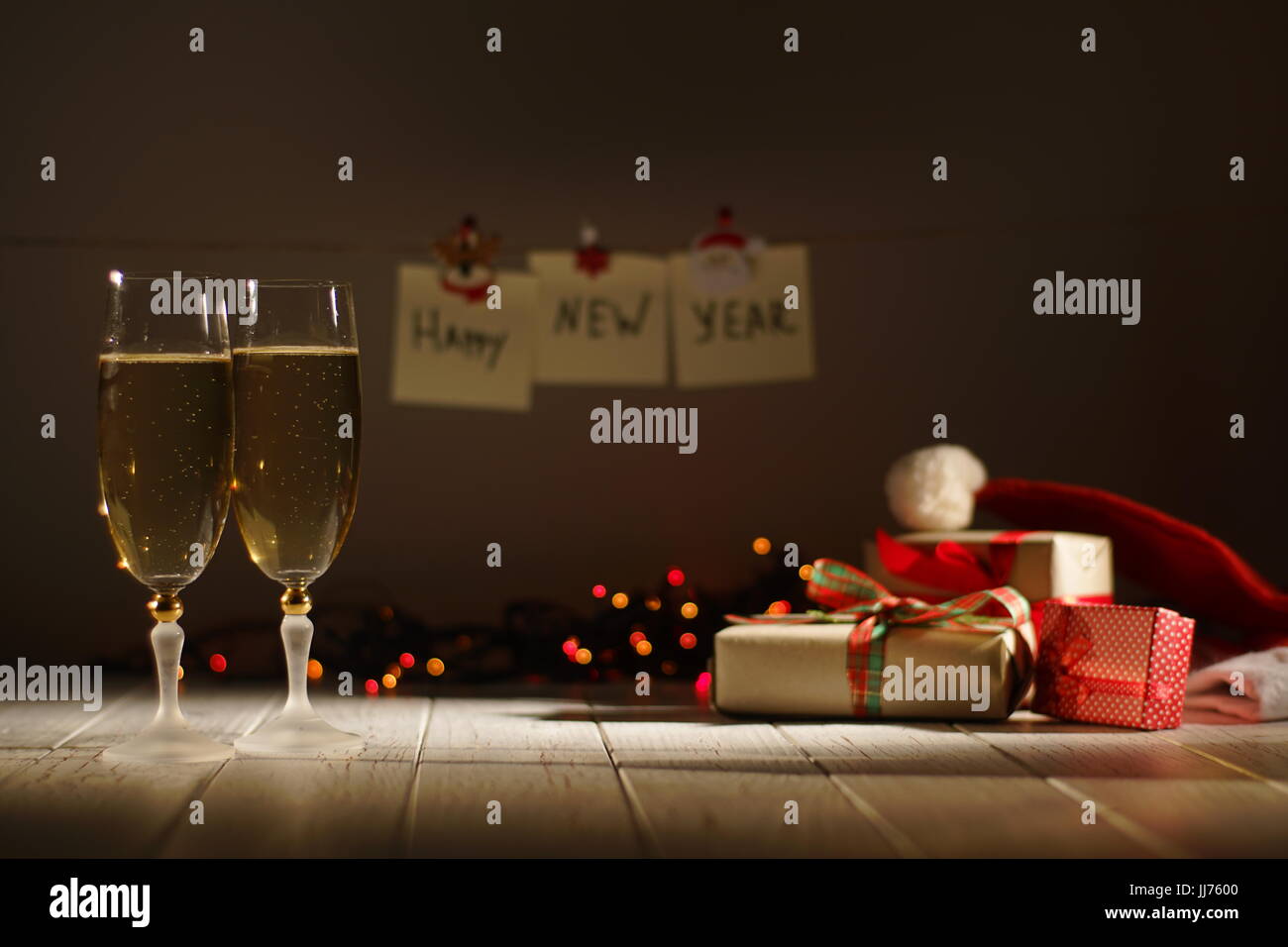 Two Glasses Of Champagne At The Blurred Background Of The Glowing Garlands Wrapped Ts And
