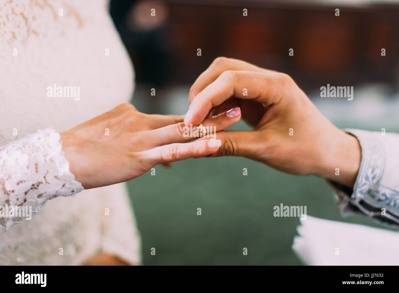 The priest is putting the wedding ring on the finger of the bride Stock