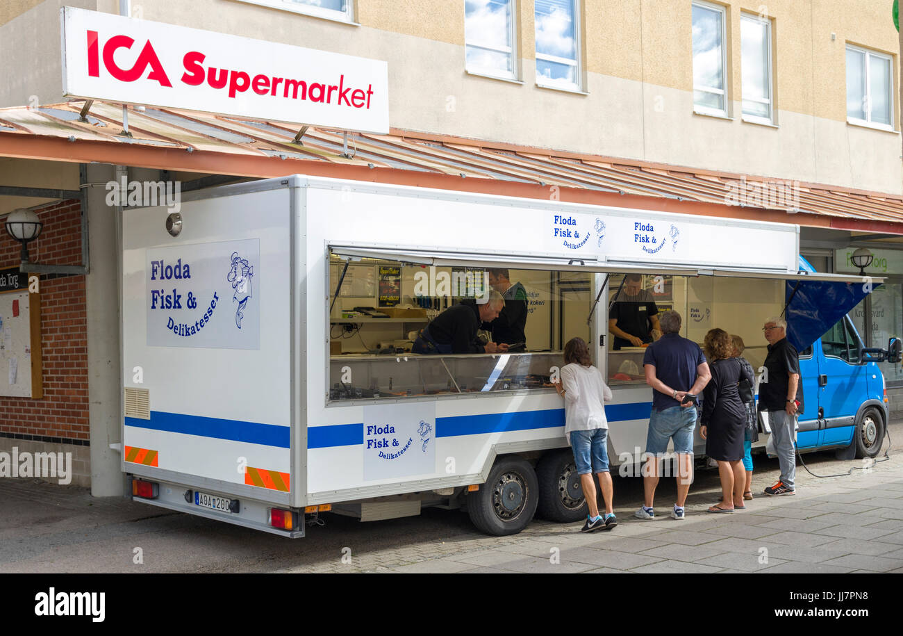 Several people buying fresh fish and seafood from fish truck parked