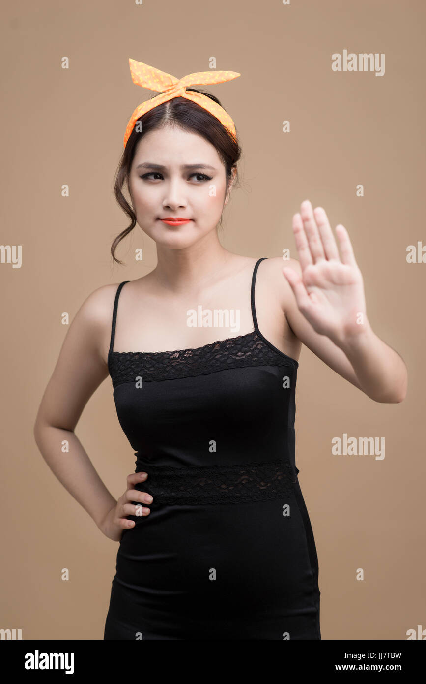 Portrait Of Asian Girl With Pretty Smile In Pinup Style With Hands Gesture On Yellow Background