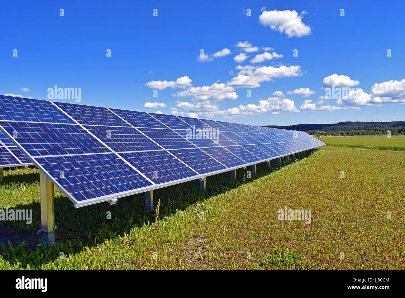 Solar panels on field. Clear sky with a few small clouds on background. Stock Photo