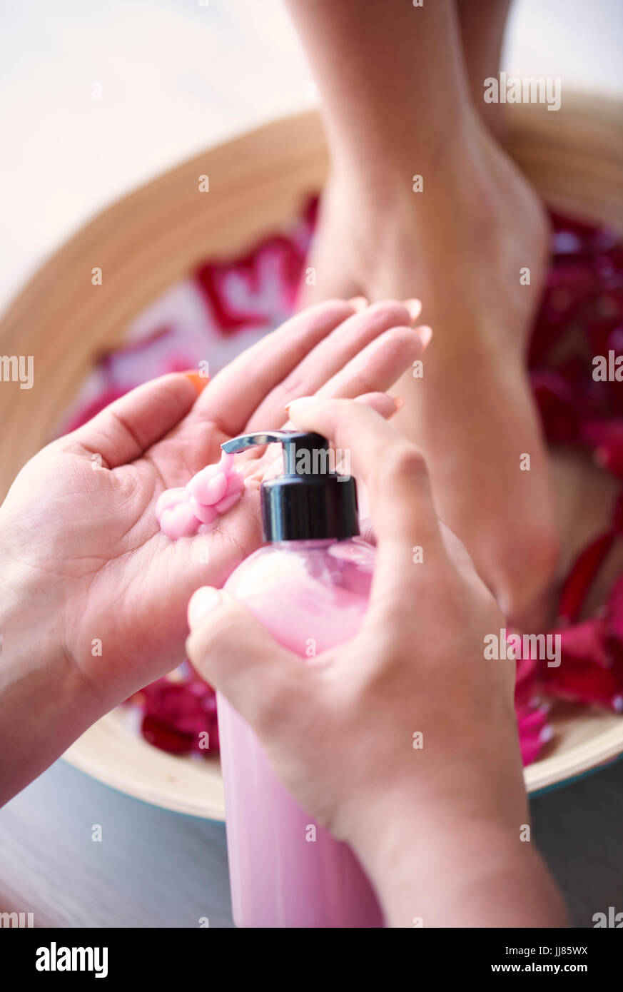 Woman's feet in bowl with water and petal Stock Photo