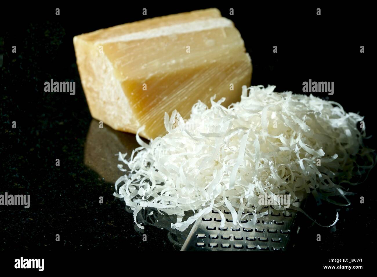 Block of Parmesan cheese with grater and grated cheese Stock Photo Alamy