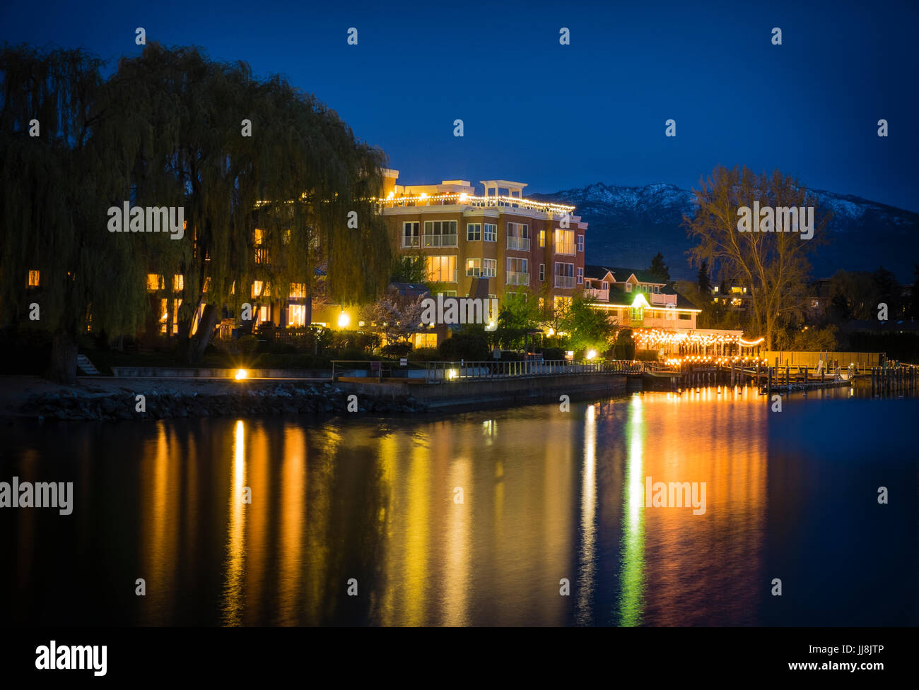Nightime lighting is reflected in the water adjacent to the Hotel Eldorado in Kelowna, British Columbia, Canada Stock Photo