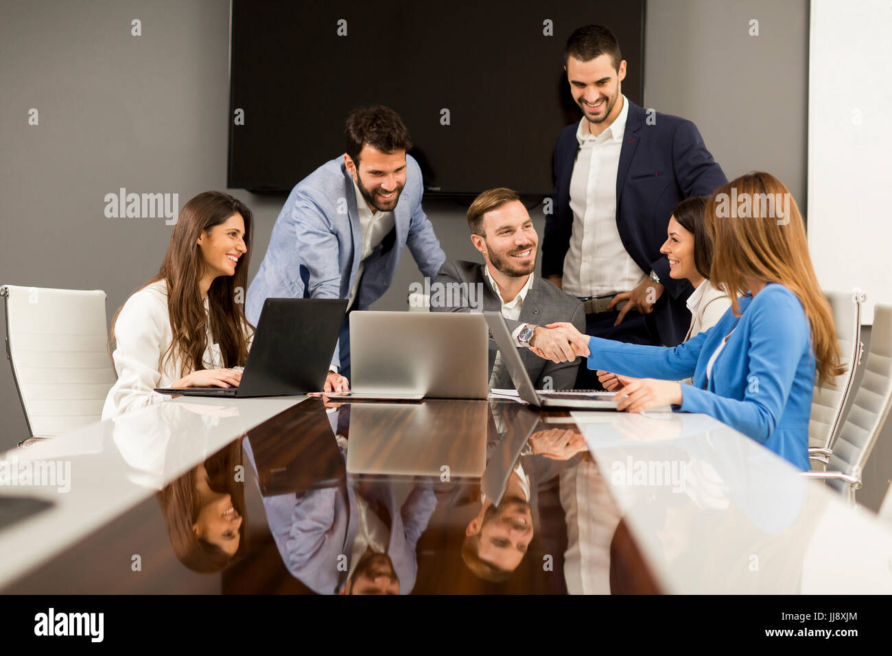 Young teamwork by the table in the office Stock Photo - Alamy