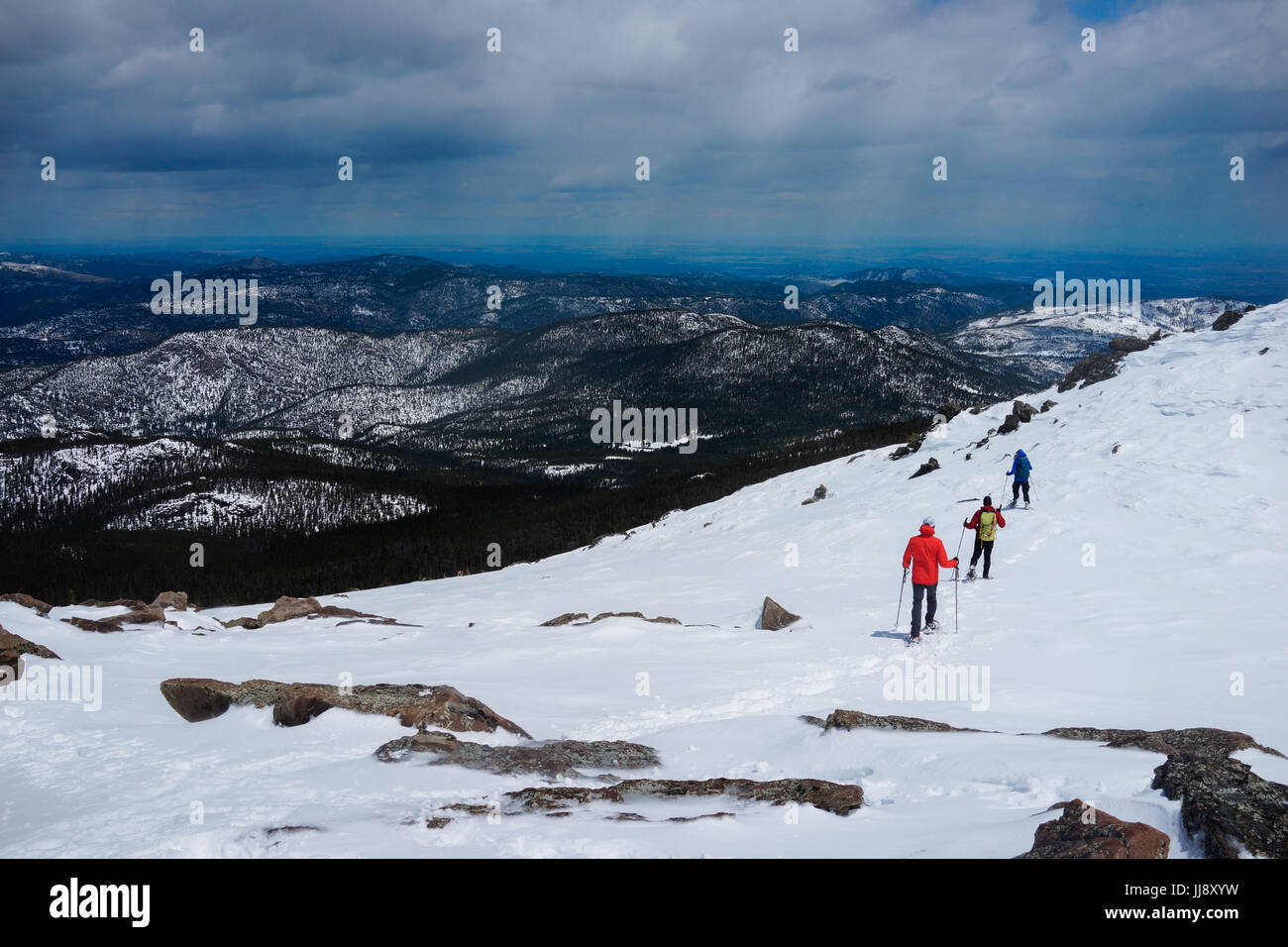 People are hiking on the top of mountain covered wit snow. Stock Photo