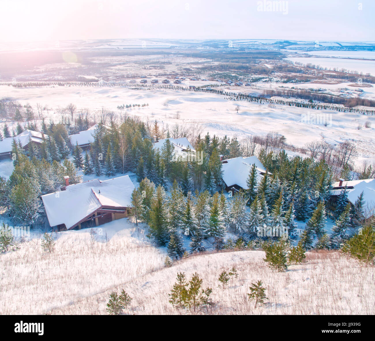 small chalets down the hill among fit trees at sunset at european skiing resort Stock Photo