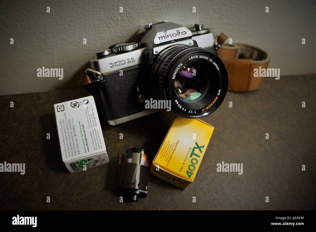 Minolta XD11 35mm camera with 50mm f1.7 lens and rolls of film Stock Photo