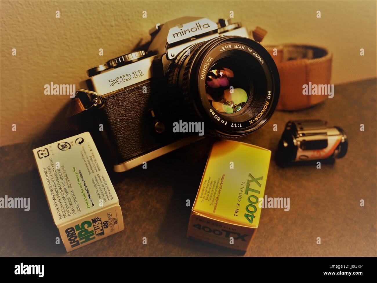 Minolta XD11 35mm camera with 50mm f1.7 lens and rolls of film Stock Photo