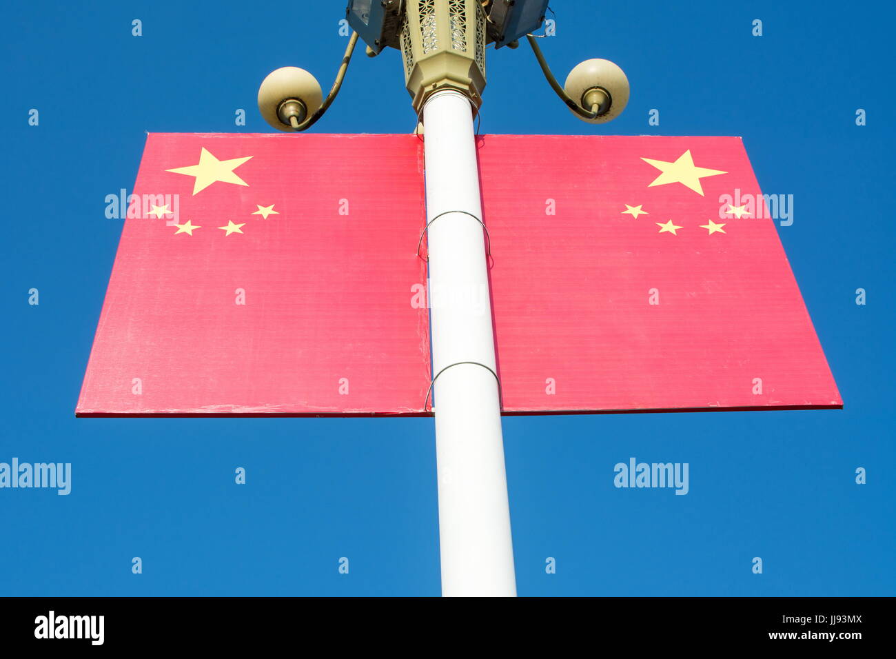 Chinese flag on the street light pillar against blue sky Stock Photo