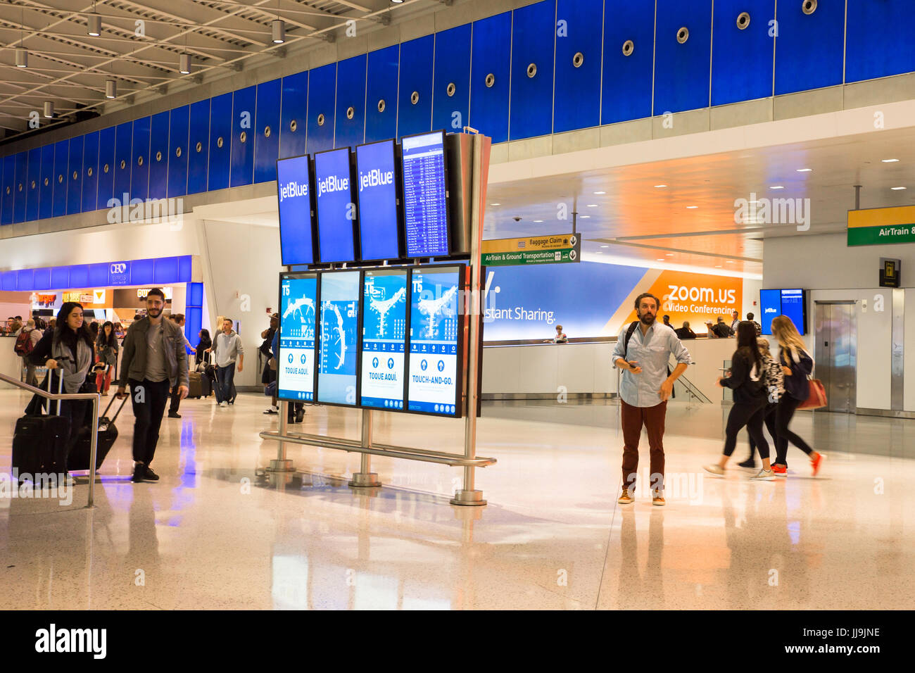 NEW YORK CITY - MAY 17, 2017:  View of the JetBlue Terminal 4 at John F. Kennedy International Airport aka JFK with travelers and arrival departure bo Stock Photo