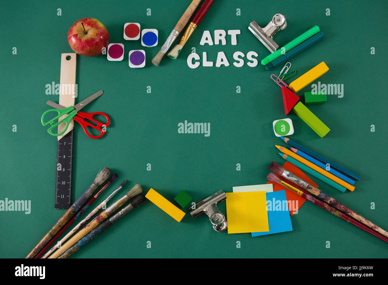 Various school supplies with text arranged on green background Stock